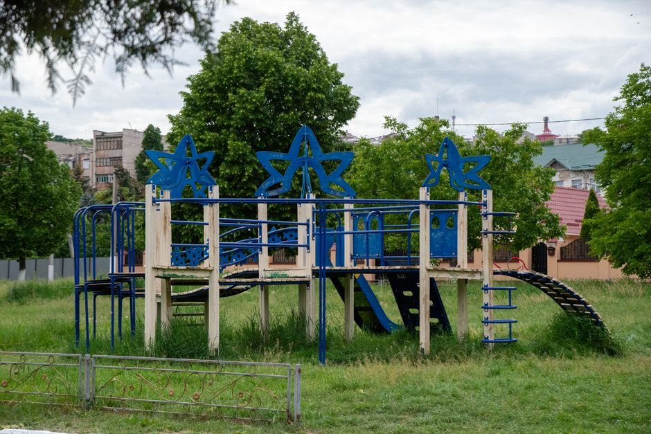 Spalvinga žvaigždžių formų žaidimų aikštelės konstrukcija vešliame parke kieme