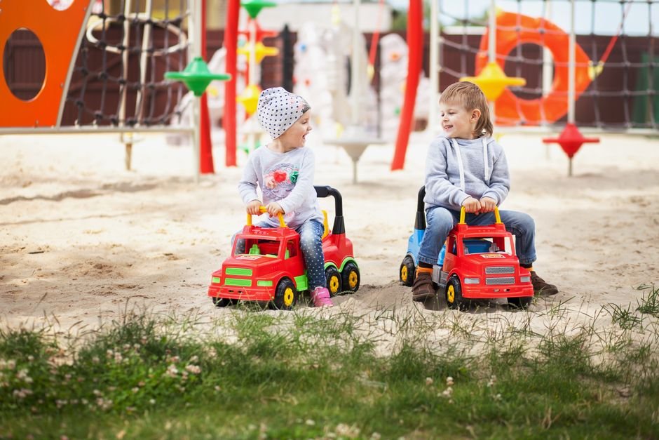 Vaikai džiaugiasi žaidimais smėlio dėžėje, išbandydami žaidimų aikštelės modelius